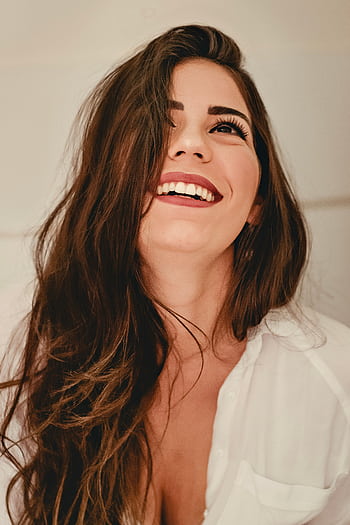 Portrait of a happy woman with long brunette hair and elegant style, expressing joy. HD phone wallpaper