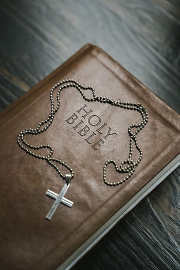Close-up of a Holy Bible with a cross necklace, emphasizing Christian faith. HD phone wallpaper