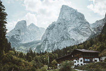 Breathtaking view of rugged mountains and a traditional house in Kufstein, Tirol. HD wallpaper