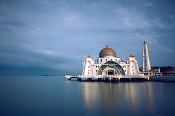 Capture of the majestic Malacca Strait Mosque in serene twilight reflecting upon calm waters. HD wallpaper