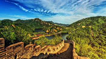 Breathtaking landscape of the Great Wall of China surrounded by lush green hills and vibrant skies. HD wallpaper
