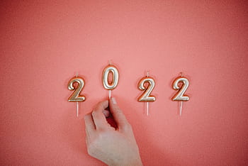 Celebrate the New Year 2022 with golden number candles on a pink backdrop. HD wallpaper