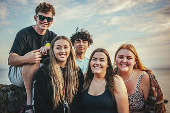 Happy young friends posing and smiling together at Avila Beach, California during a sunny day. HD wallpaper