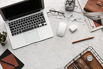 Discover a clean, organized workspace featuring a laptop, AirPods, and stationery essentials on a marble desk. HD wallpaper