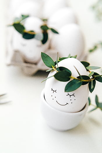 Cute Easter egg with a smiley face and leaf crown, perfect for holiday decoration and spring celebrations. HD phone wallpaper