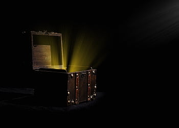 Open wooden chest emitting a mysterious glowing light in a dark room. HD wallpaper