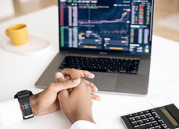 Close-up of a person analyzing stock data on a laptop with graphs and charts visible. HD wallpaper