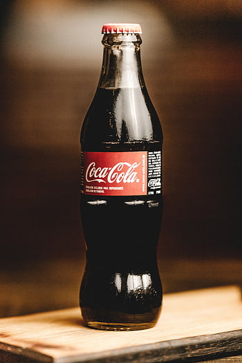 Close-up of a chilled Coca-Cola glass bottle, perfect for refreshing moments. HD phone wallpaper