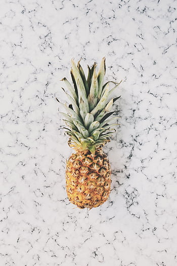A vibrant pineapple on a minimalist marble texture surface, evoking tropical freshness and health. HD phone wallpaper