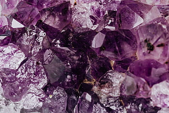 Macro shot of natural purple amethyst crystals showcasing their vibrant hues and intricate formations. HD wallpaper
