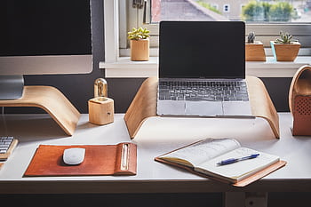 A stylish and contemporary home office setup with laptop and desk accessories. HD wallpaper