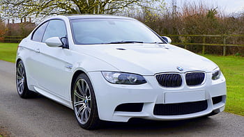 A sleek and stylish white BMW coupe car parked on a paved road, perfect for luxury transportation. HD wallpaper