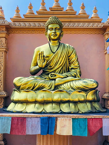 Magnificent golden Buddha statue in a serene temple setting, epitomizing spirituality and peace. HD phone wallpaper