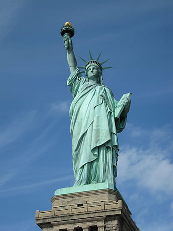 The Statue of Liberty serves as a symbol of dom against a clear blue sky in New York City. HD phone wallpaper