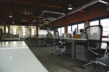 Open-plan industrial coworking space with modern design and natural lighting. HD wallpaper