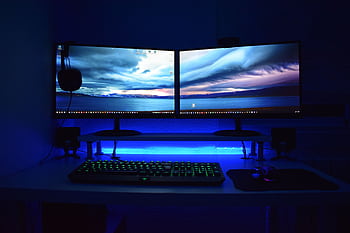Dual monitors with blue lighting on a gaming desk setup. HD wallpaper