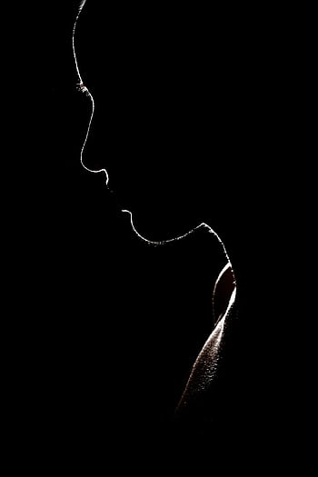 Artistic silhouette of a person against a dark background, evoking mystery and solitude. HD phone wallpaper