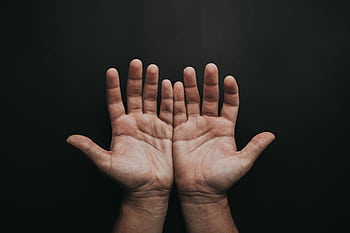 A pair of upturned hands displayed against a dark background, showcasing skin texture. HD wallpaper