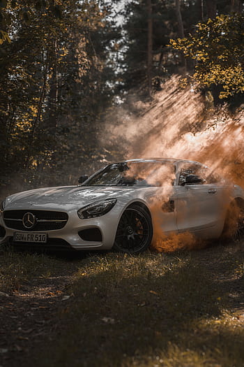 A luxury white Mercedes Benz parked in a misty forest with dramatic lighting effects. HD phone wallpaper
