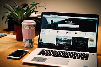 A tidy desk setting with a laptop showing a stock website and a smart. HD wallpaper