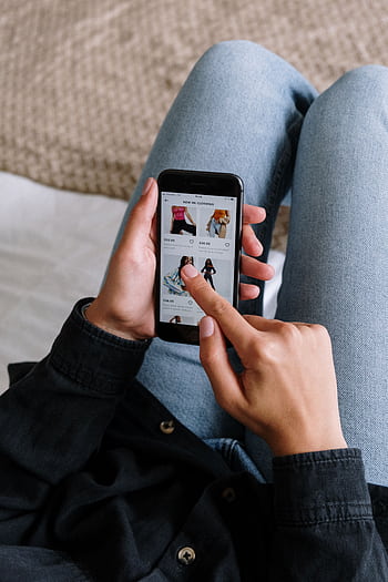 Close-up of a woman shopping online on a smart while relaxing at home. HD phone wallpaper