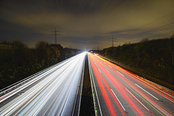 Captivating long exposure showcasing dynamic light trails on a nighttime highway. HD wallpaper