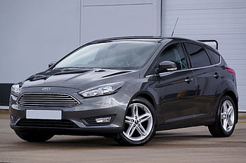 A sleek grey hatchback car parked outdoors, showcasing its modern design and shiny finish. HD wallpaper