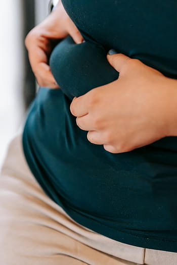 Close-up of a woman grabbing her waist in sportswear, symbolizing weight loss and fitness. HD phone wallpaper