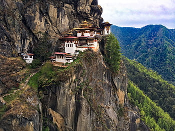 A breathtaking view of the iconic Tiger's Nest Monastery perched on a cliff in Bhutan's lush landscape. HD wallpaper
