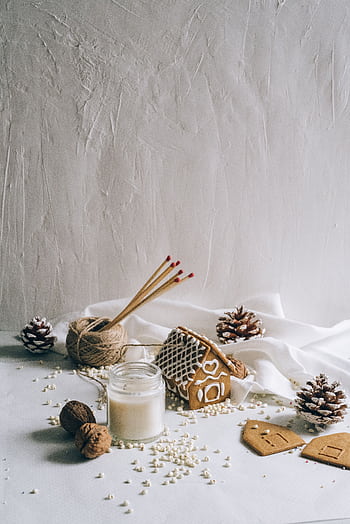 Cozy gingerbread house with pine cones and candle, perfect for holiday warmth. HD phone wallpaper