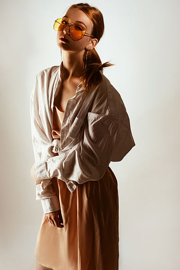 Trendy woman posing in oversized shirt and sunglasses, exuding modern fashion style. HD phone wallpaper