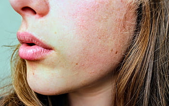 Detailed close-up of a woman's facial skin showing natural texture and complexion. HD wallpaper