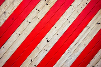 Close-up of wooden planks with alternating red and natural tones, creating a bold pattern. HD wallpaper