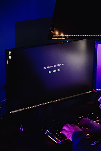 A hacker typing on a keyboard in a dimly lit room, highlighting cybersecurity threats at night. HD phone wallpaper