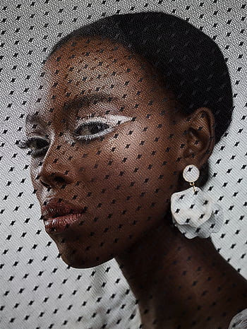 Creative fashion portrait of a woman with bold makeup and statement earrings behind a mesh veil. HD phone wallpaper
