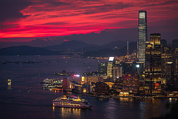 A breathtaking view of the Hong Kong skyline illuminated at sunset with a vibrant red sky. HD wallpaper