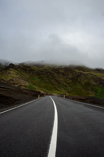 Discover the allure of Iceland's misty roads winding through dramatic landscapes, perfect for travel and adventure enthusiasts. HD phone wallpaper
