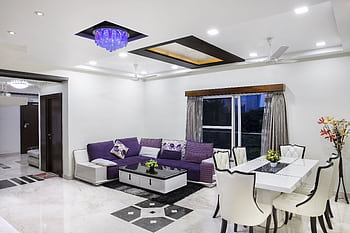 Elegant living room with modern decor, featuring a purple sofa and chic dining area. HD wallpaper