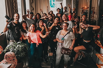 Diverse group enjoying a cheerful meeting indoors in São Paulo, capturing unity and joy. HD wallpaper