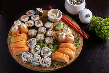 A beautifully arranged platter of assorted sushi, showcasing Japanese culinary art. HD wallpaper