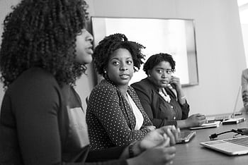 Three black women engaged in a serious discussion at an office meeting. HD wallpaper