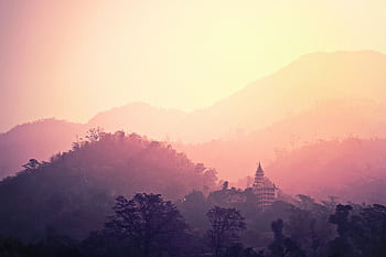 A tranquil view of Rishikesh mountains and temple enveloped in pink hues at sunrise. HD wallpaper