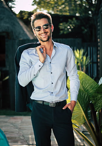 Confident young man in a stylish suit outdoors, exuding charm and elegance. HD phone wallpaper