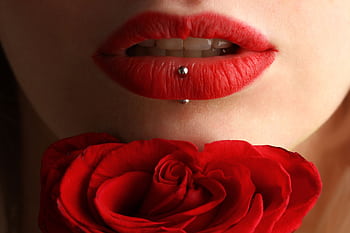 Aesthetic close-up featuring red lipstick, lip piercing, and a red rose. HD wallpaper