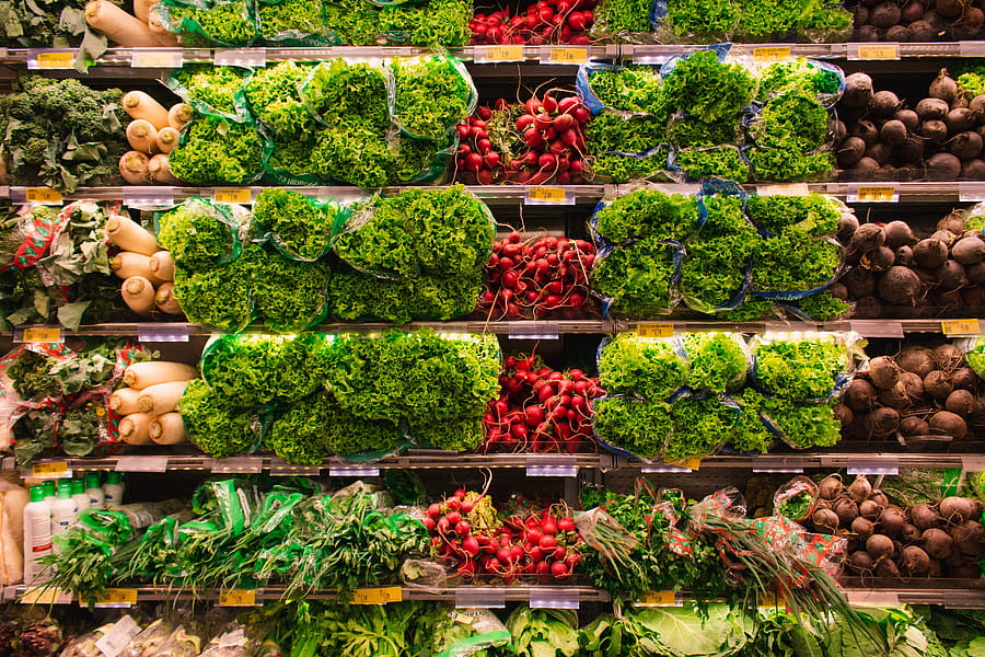 Colorful assortment of fresh vegetables arranged on supermarket shelves, perfect for healthy eating themes. HD wallpaper