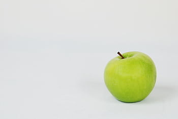 A single green apple placed against a crisp white background, perfect for food graphy. HD wallpaper