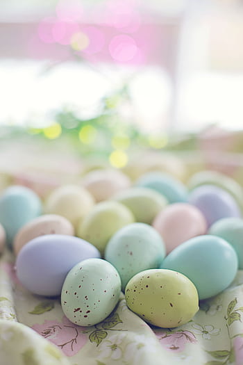 A vibrant collection of pastel Easter eggs on a soft floral background, perfect for spring celebrations. HD phone wallpaper