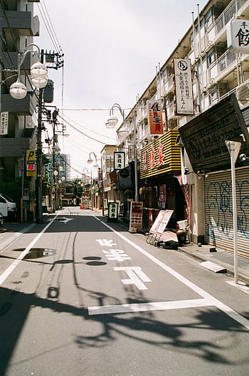Empty street scene in Tokyo, Japan showcasing traditional Japanese shopfronts and urban architecture. HD phone wallpaper