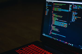 Red backlit keyboard and code on laptop screen create a tech-focused ambiance. HD wallpaper