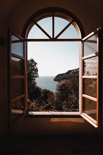 Elegant arched window view of a serene ocean landscape with lush greenery. HD phone wallpaper